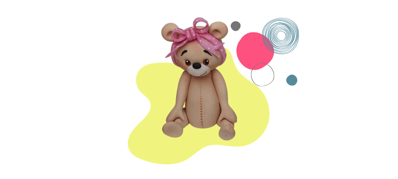 A cute teddy bear with a pink ribbon sits on a yellow abstract shape with colorful circles in the background, perfect as a fondant cake topper.