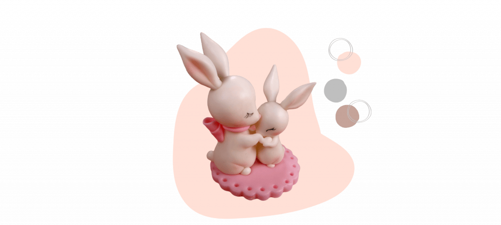 A mother bunny holding a baby bunny on a pink, heart-shaped base with three color samples (white, gray, and pink) to the right—perfect for crafting a fondant cake topper.
