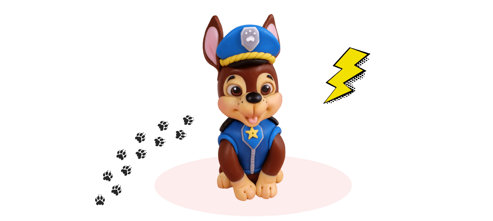 A fondant cake topper features a cartoon dog in a police uniform sitting on a white oval with paw prints behind and a yellow lightning bolt to the right, perfect for any PAW Patrol fan.